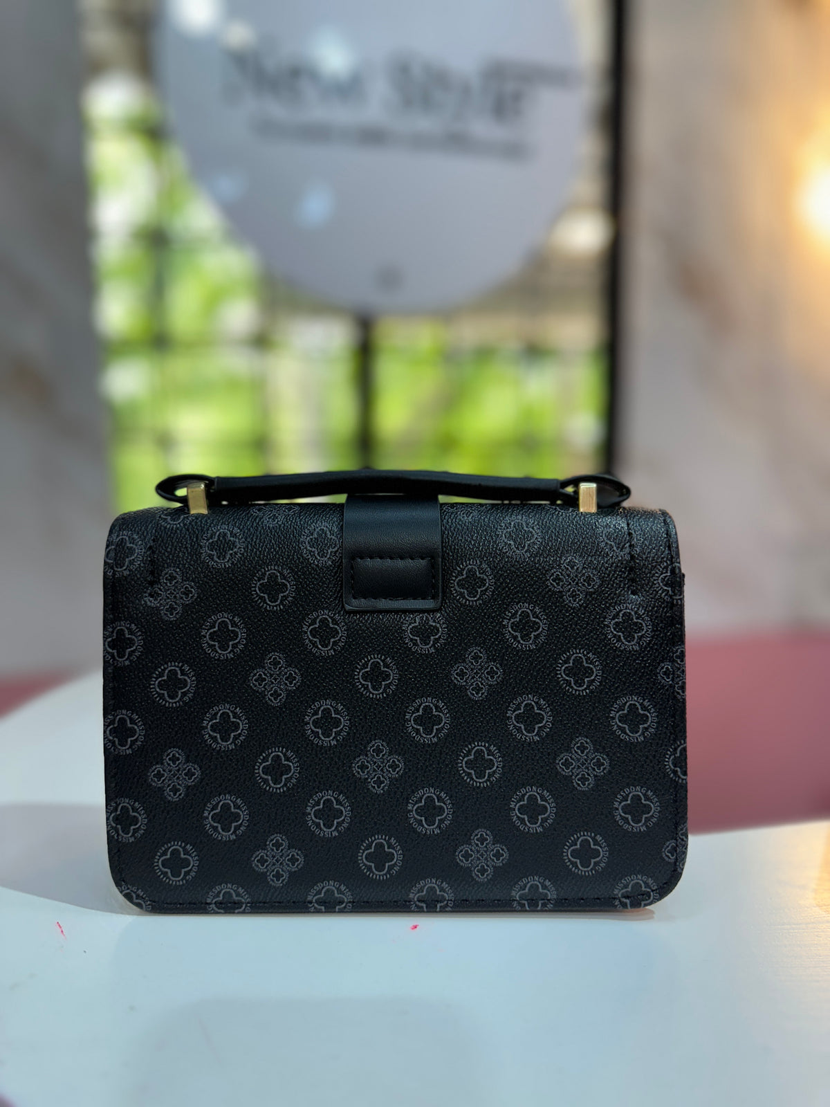 Cartera elegante con monedero incluido y correa ajustable, destaca por su estampado geométrico