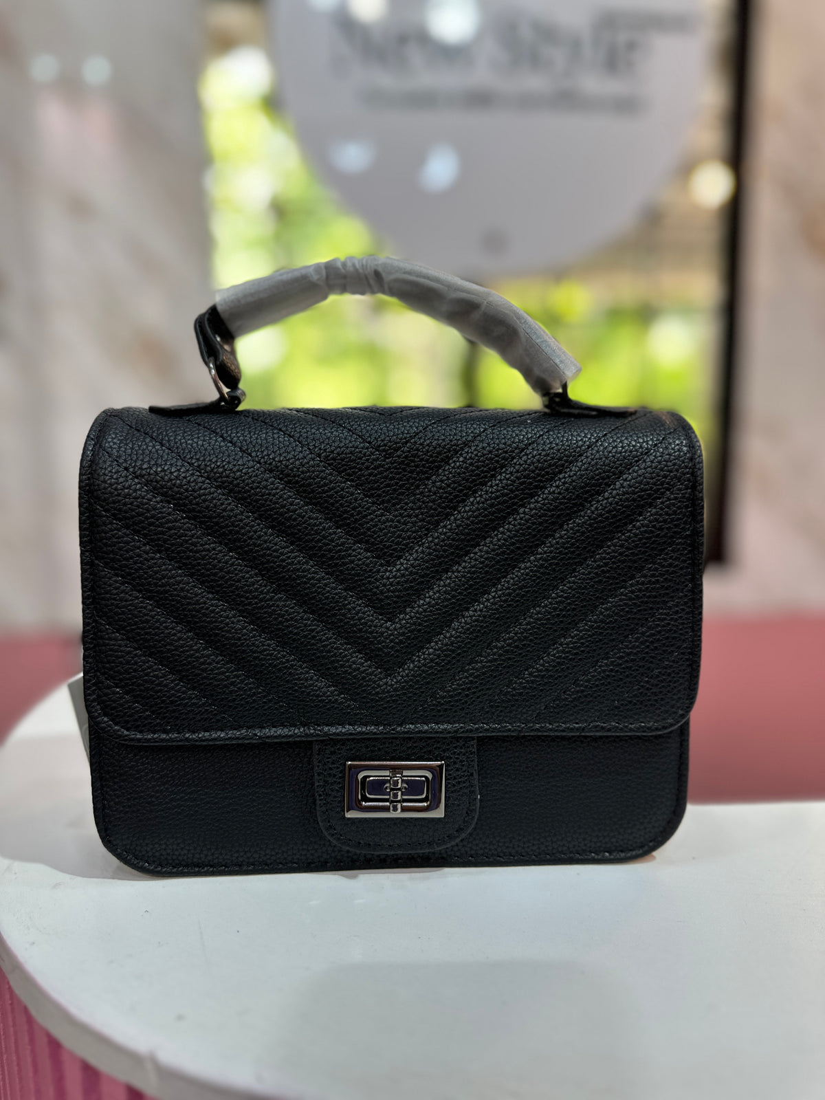 Cartera en color negro con diseño acolchado y correa ajustable a juego