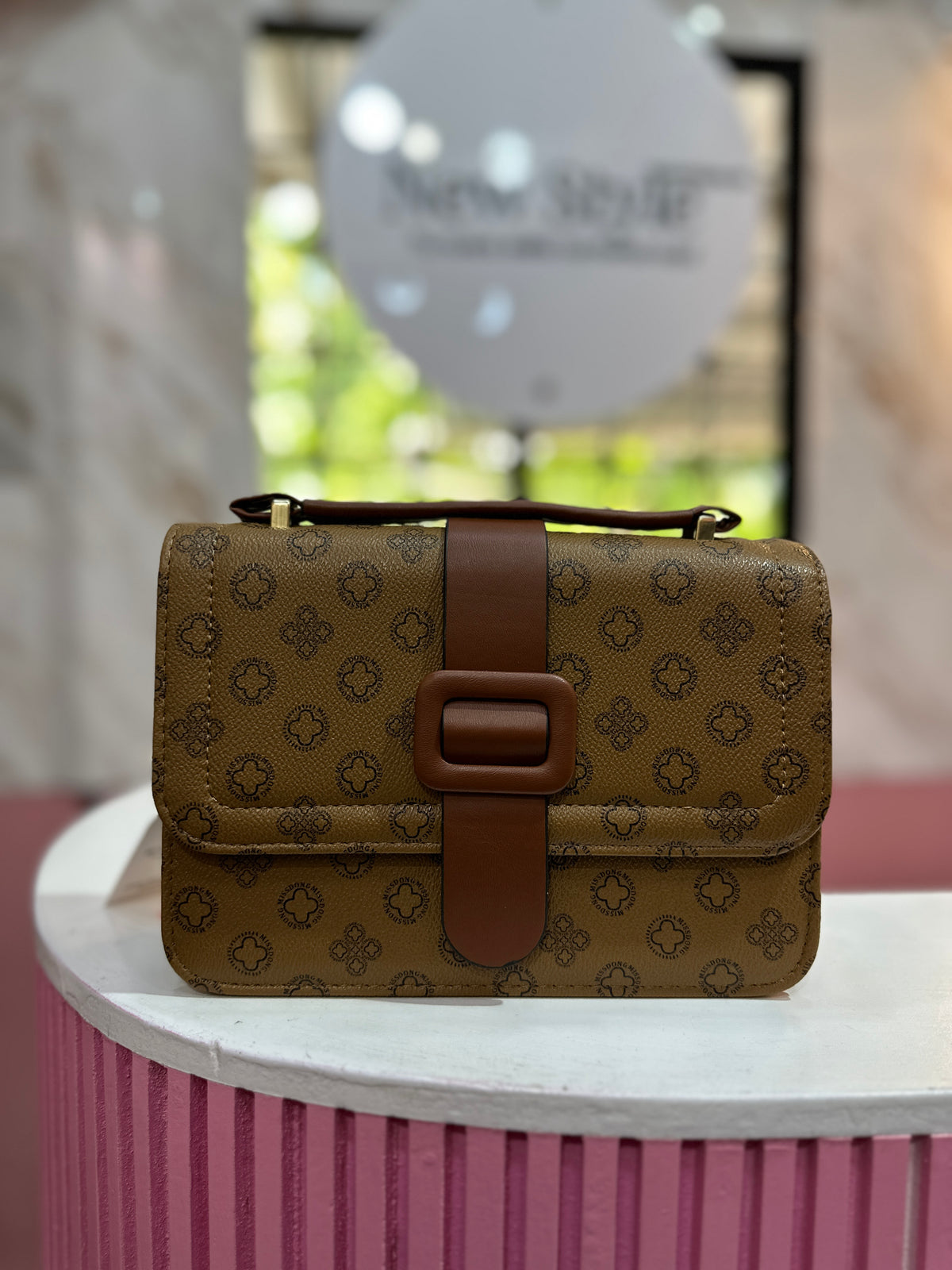 Cartera elegante en tono café con diseño estampado, cierre elegante y correa ajustable