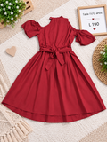 Vestido color vino para niña con hombros descubiertos, mangas abullonadas y un cinturón de lazo en la cintura