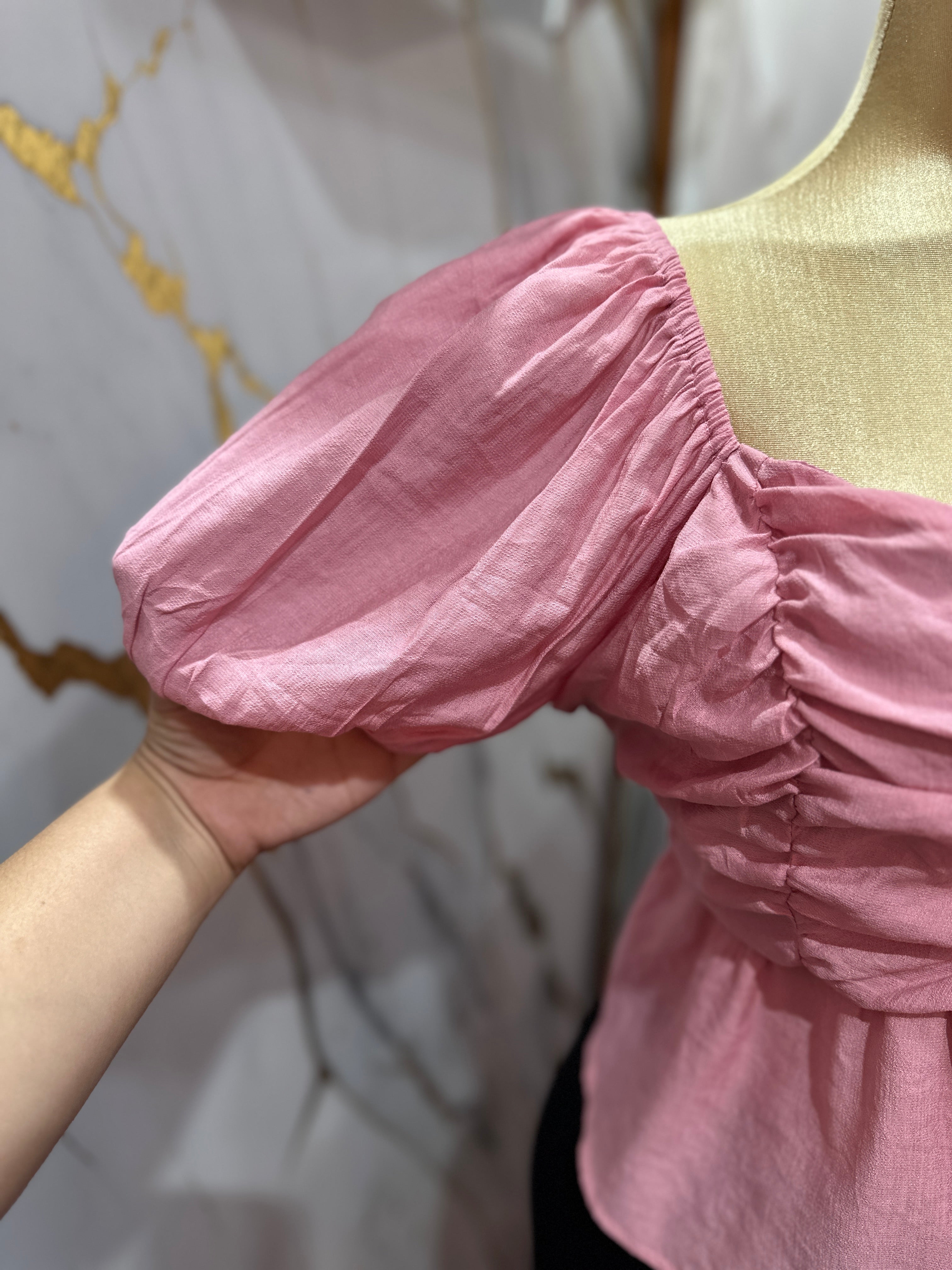 Blusa rosada con mangas abullonadas con diseño fruncido en el frente