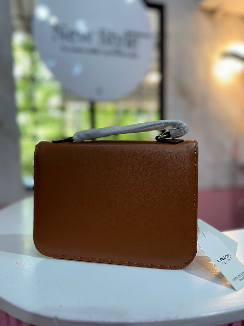 Cartera en color café con combinación de texturas y correa ajustable a juego