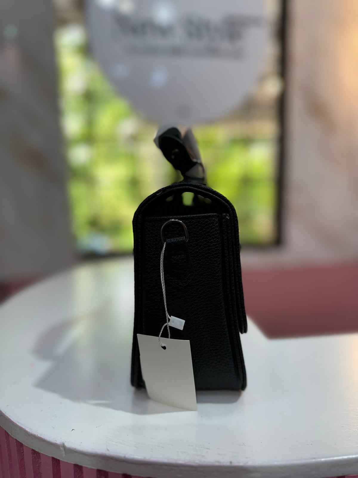 Cartera en color negro con diseño acolchado y correa ajustable a juego