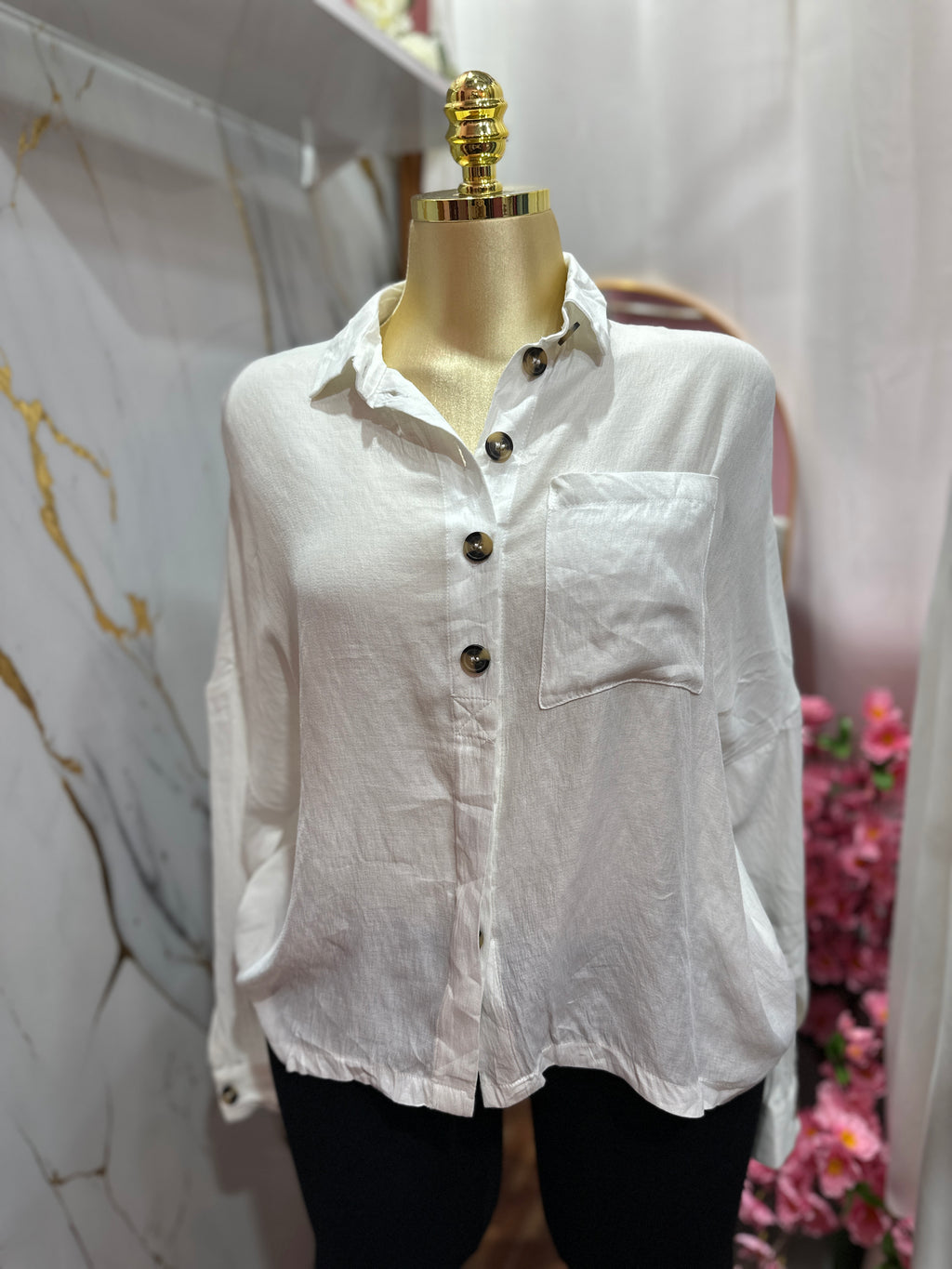Camisa blanca estilo holgado con diseño de botones frontales