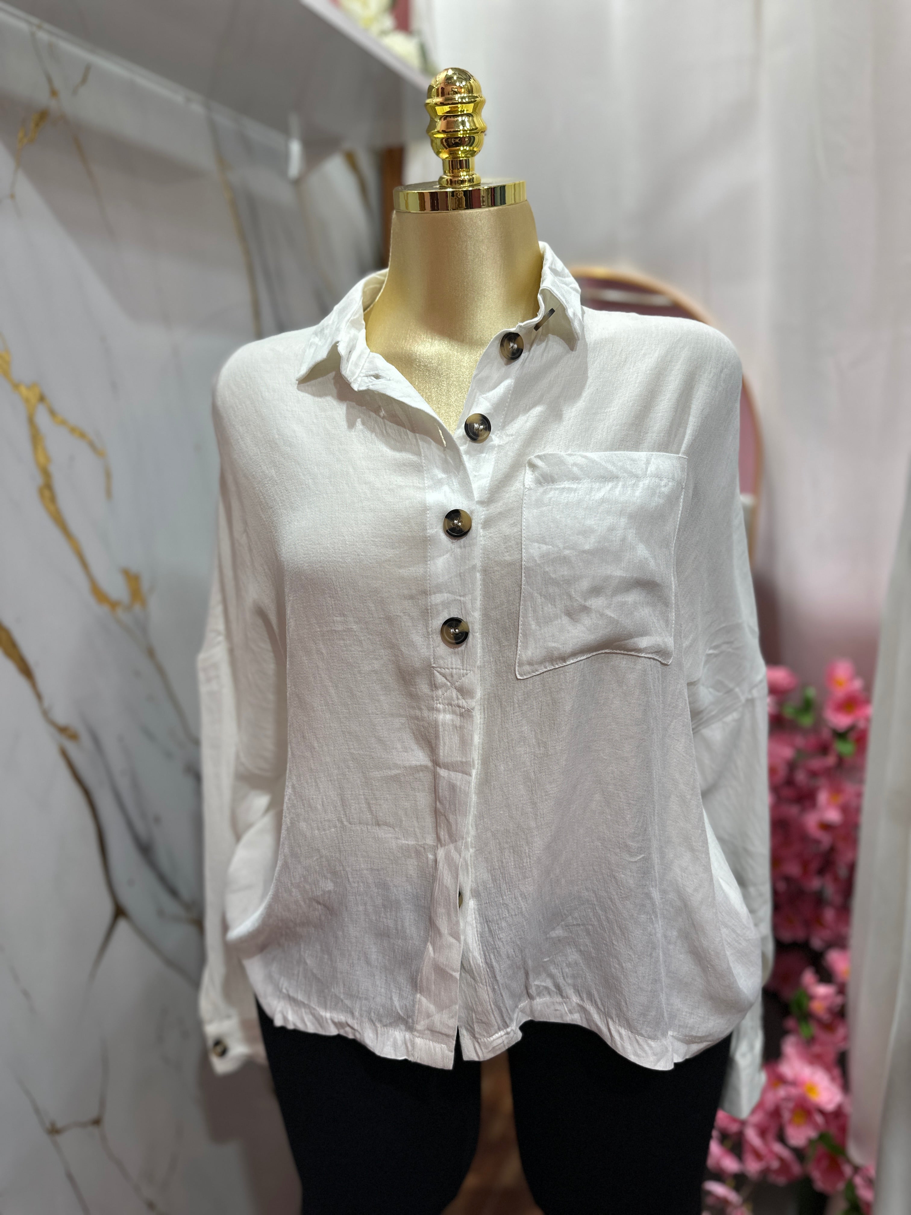 Camisa blanca estilo holgado con diseño de botones frontales