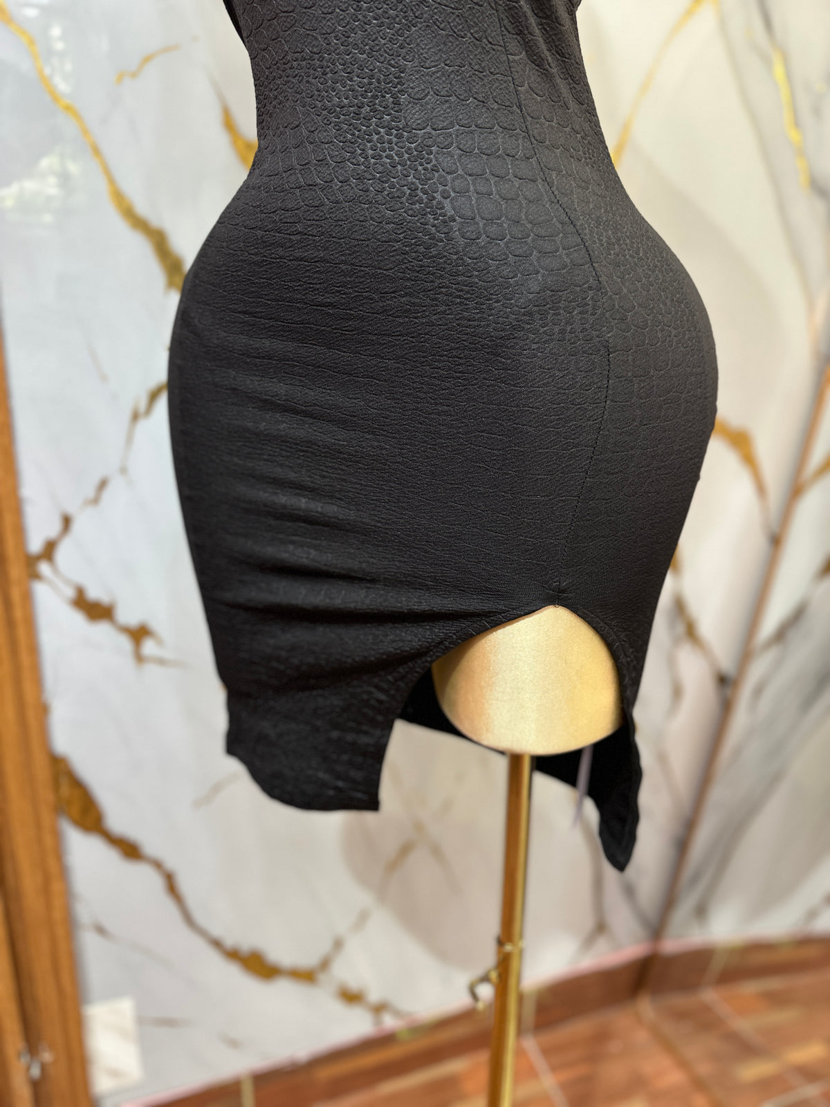 Vestido corto color negro ajustado con abertura lateral destaca por su espalda descubierta