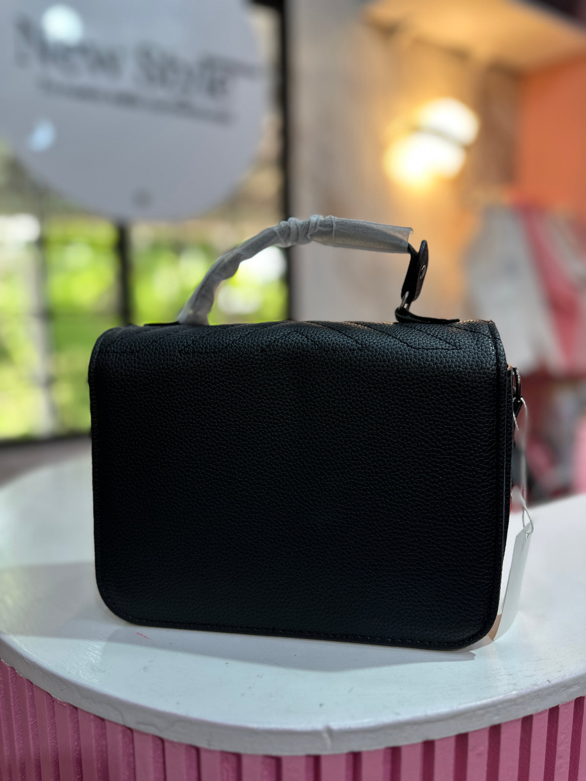 Cartera en color negro con diseño acolchado y correa ajustable a juego