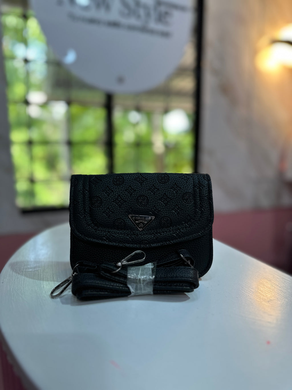 Mini cartera en color negro con estampado elegante y correa ajustable