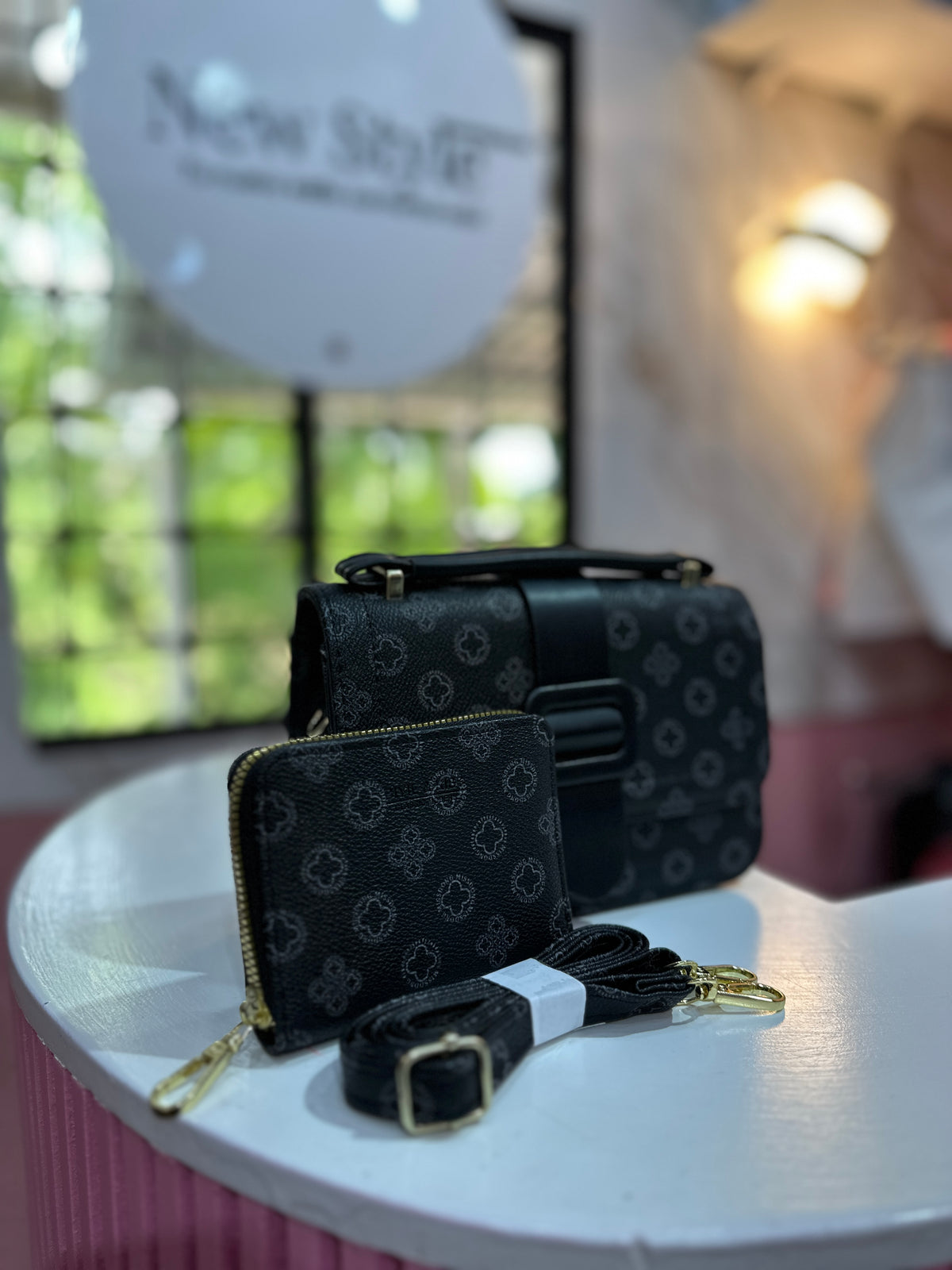 Cartera elegante con monedero incluido y correa ajustable, destaca por su estampado geométrico