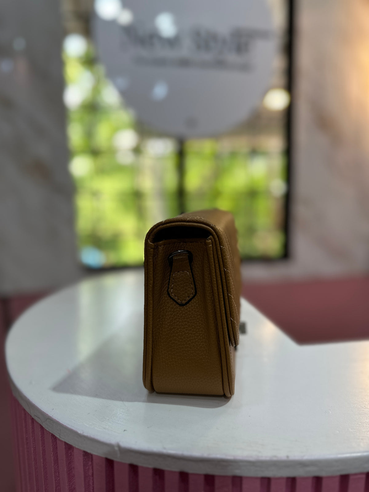 Cartera de color café con textura acolchada y correa ajustable a juego