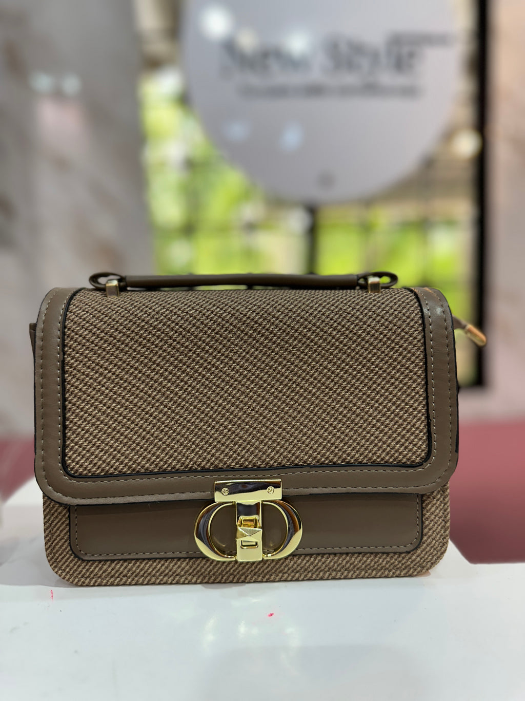 Cartera elegante en tono café con diseño texturizado y con correa ajustable