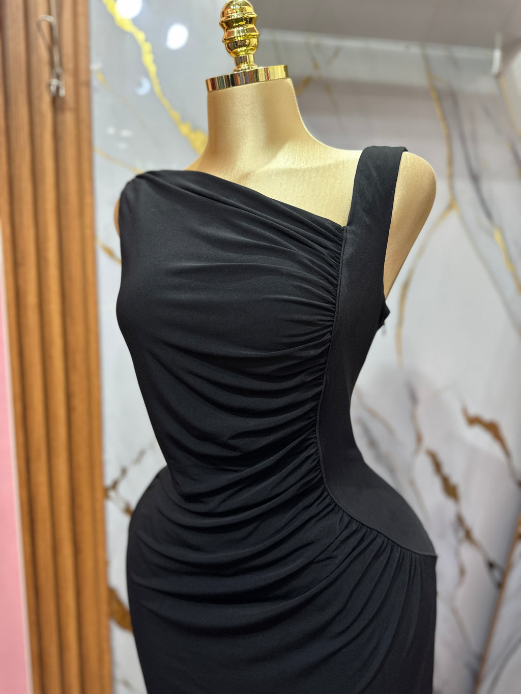 Vestido elegante negro con diseño asimétrico y detalles de drapeado