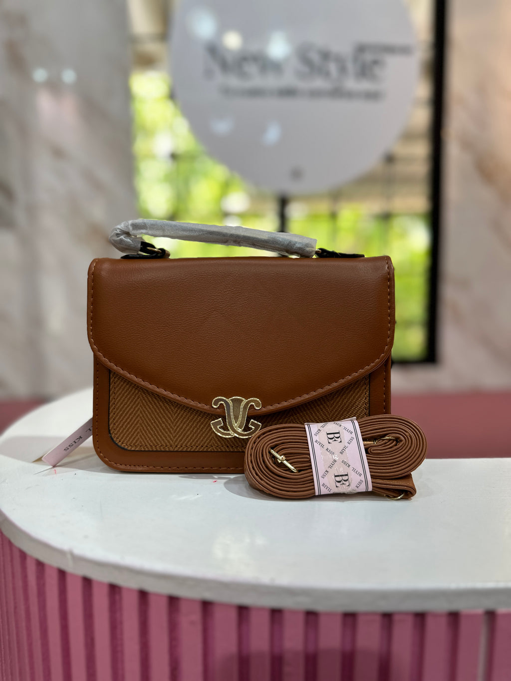 Cartera en color café con combinación de texturas y correa ajustable a juego
