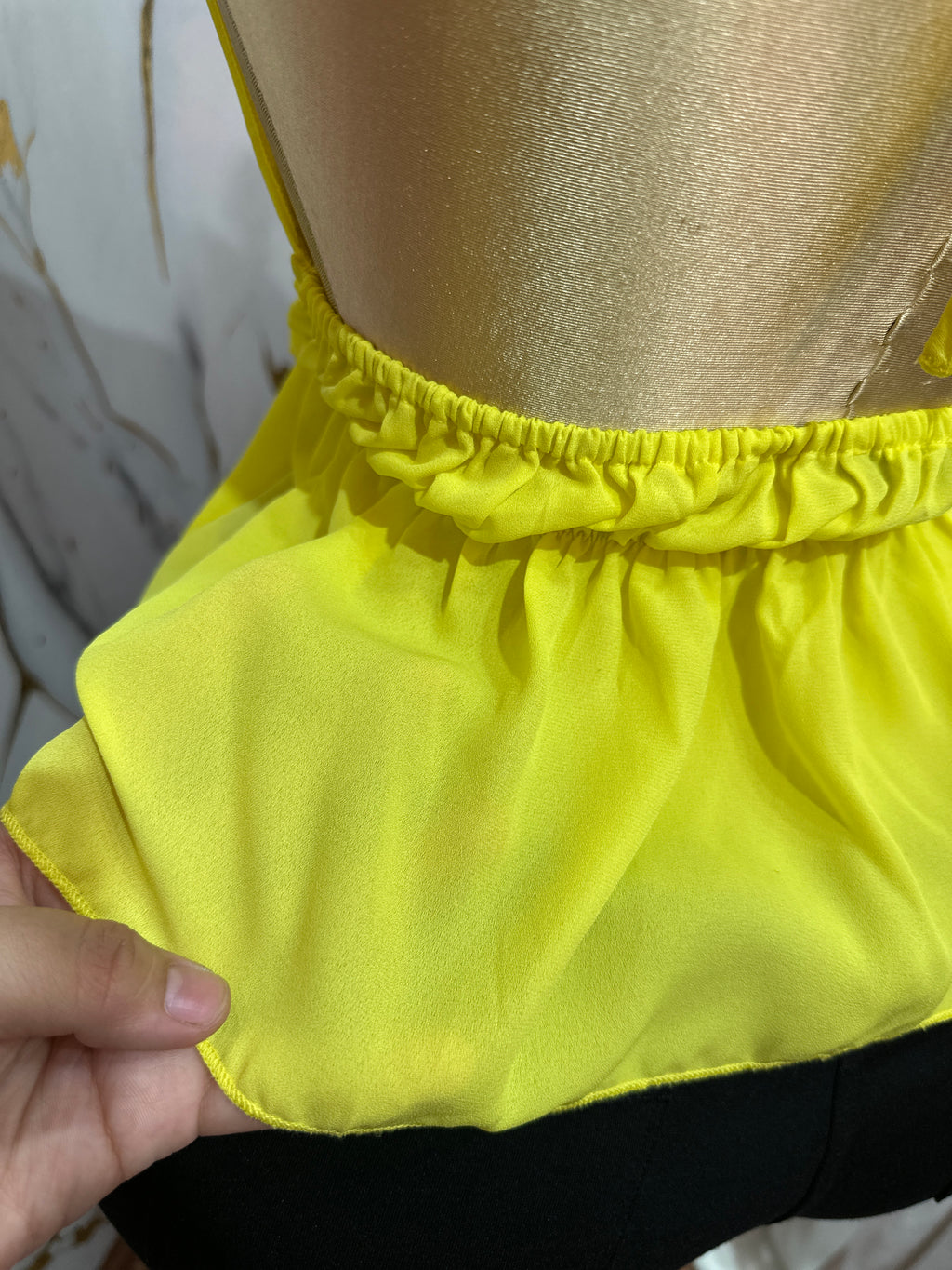 Blusa amarilla con cuello halter y volantes en la cintura
