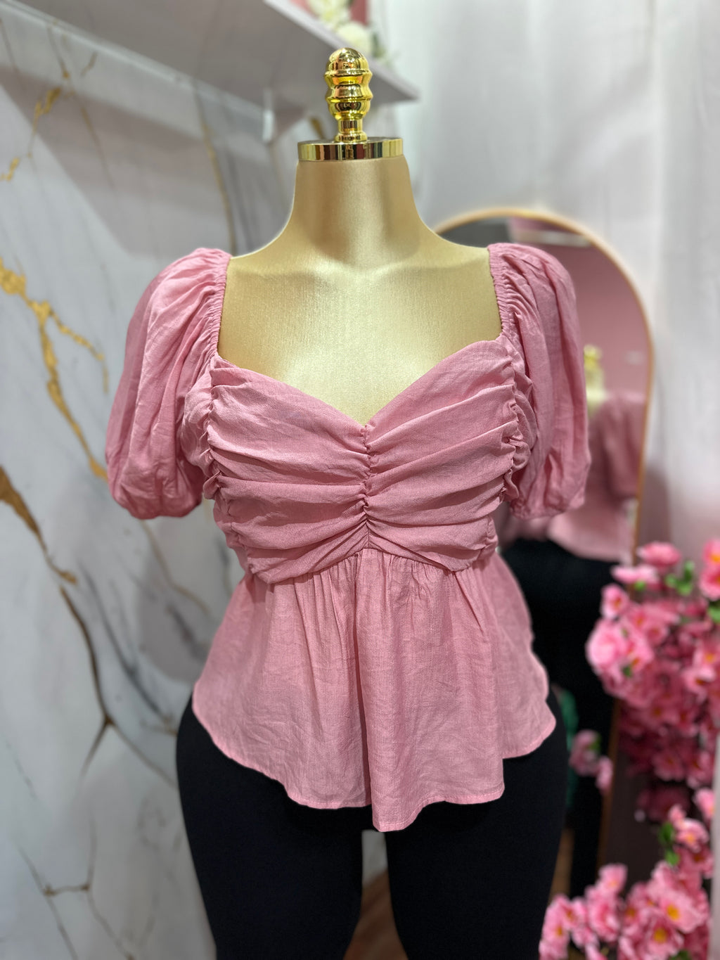 Blusa rosada con mangas abullonadas con diseño fruncido en el frente