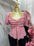 Blusa rosada con mangas abullonadas con diseño fruncido en el frente