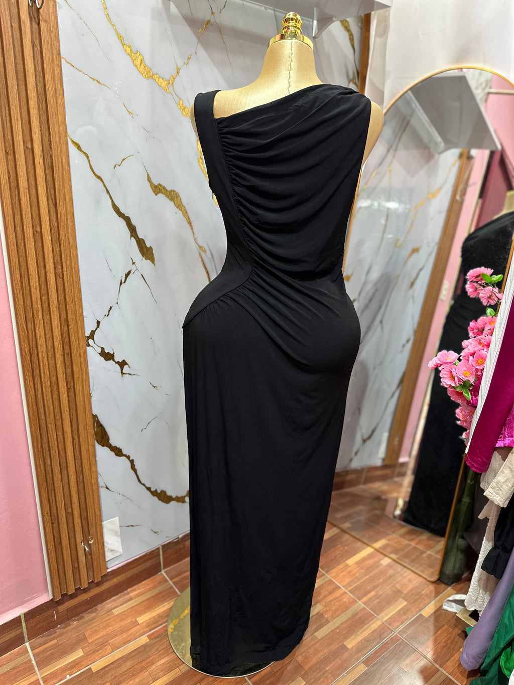 Vestido elegante negro con diseño asimétrico y detalles de drapeado