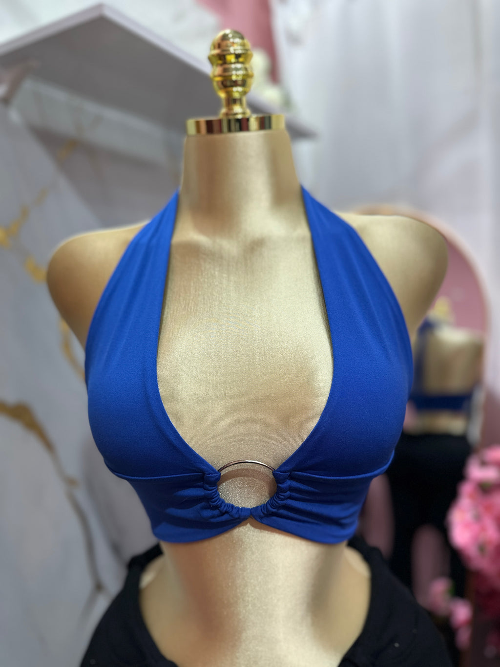 Top halter azul presenta un llamativo detalle de anillo metálico en el centro del busto