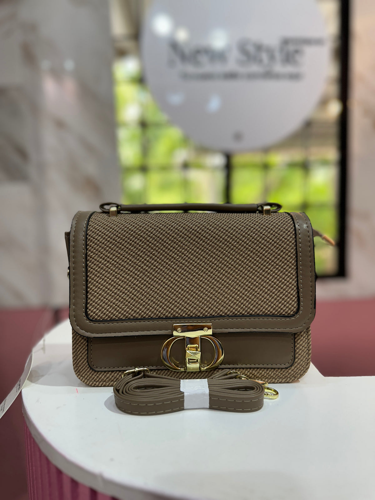 Cartera elegante en tono café con diseño texturizado y con correa ajustable