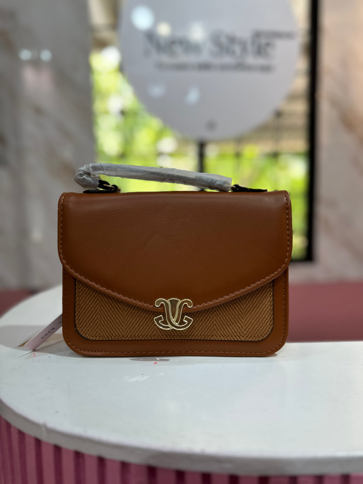 Cartera en color café con combinación de texturas y correa ajustable a juego