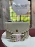 Cartera de color crema con textura granulada y con correa ajustable