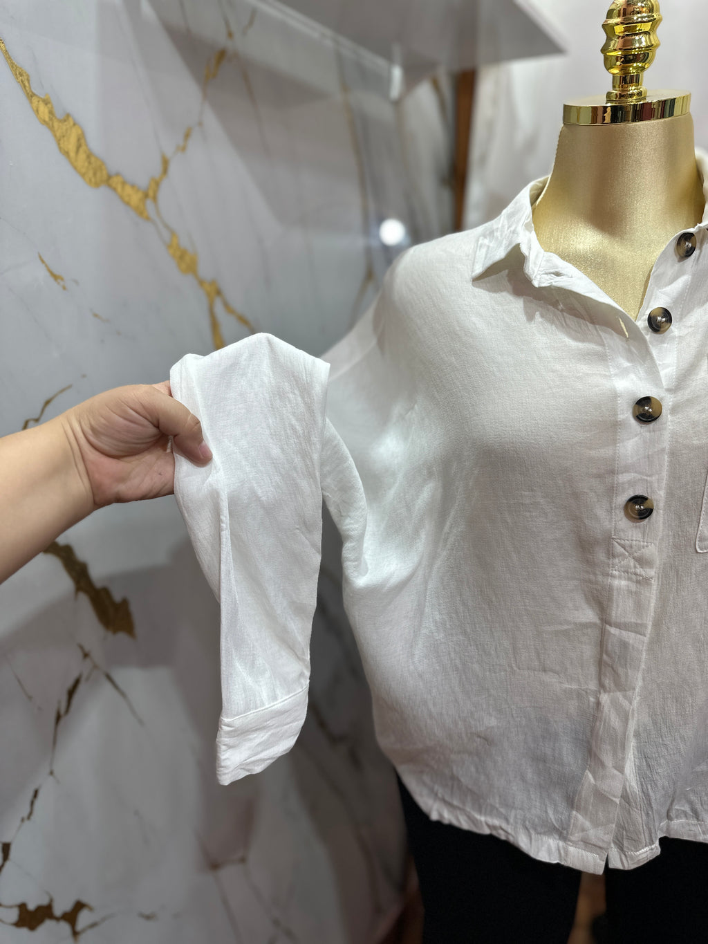 Camisa blanca estilo holgado con diseño de botones frontales