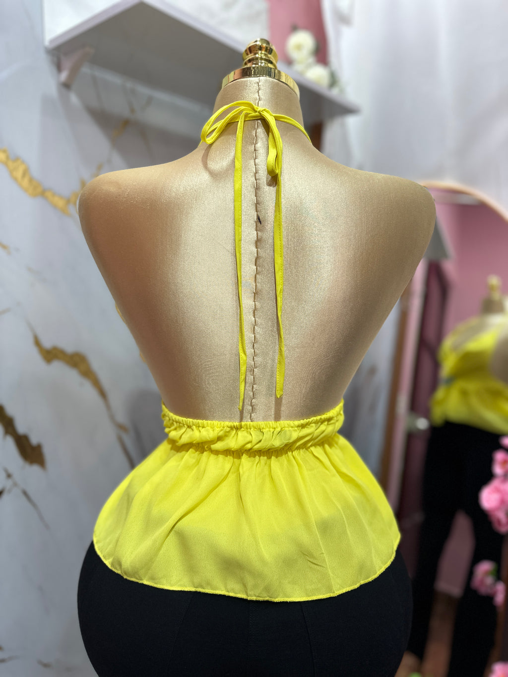 Blusa amarilla con cuello halter y volantes en la cintura