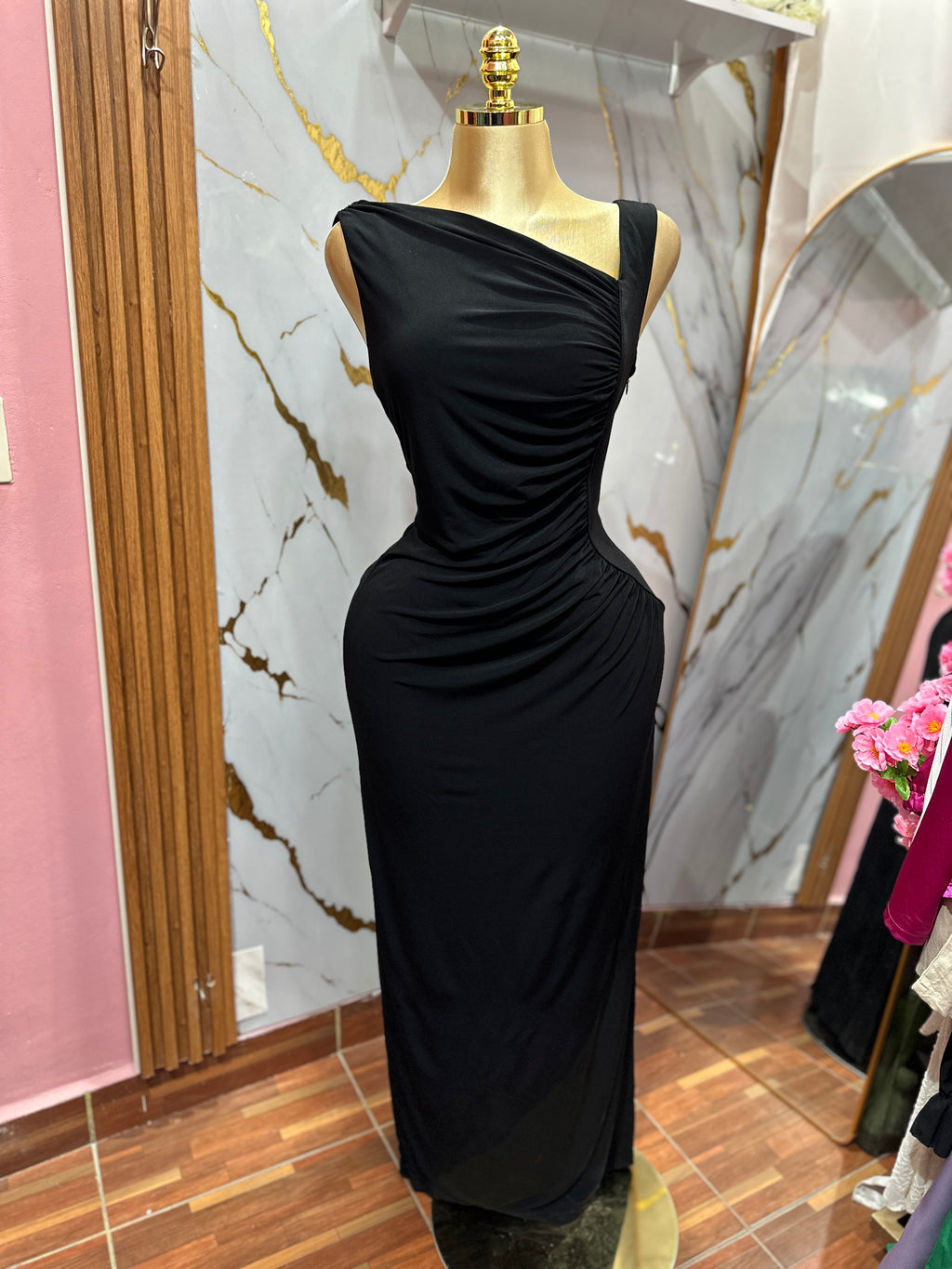 Vestido elegante negro con diseño asimétrico y detalles de drapeado