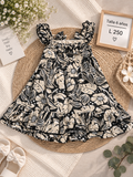 Vestido para niña con estampado tropical en tonos negros y beiges decorado con volantes