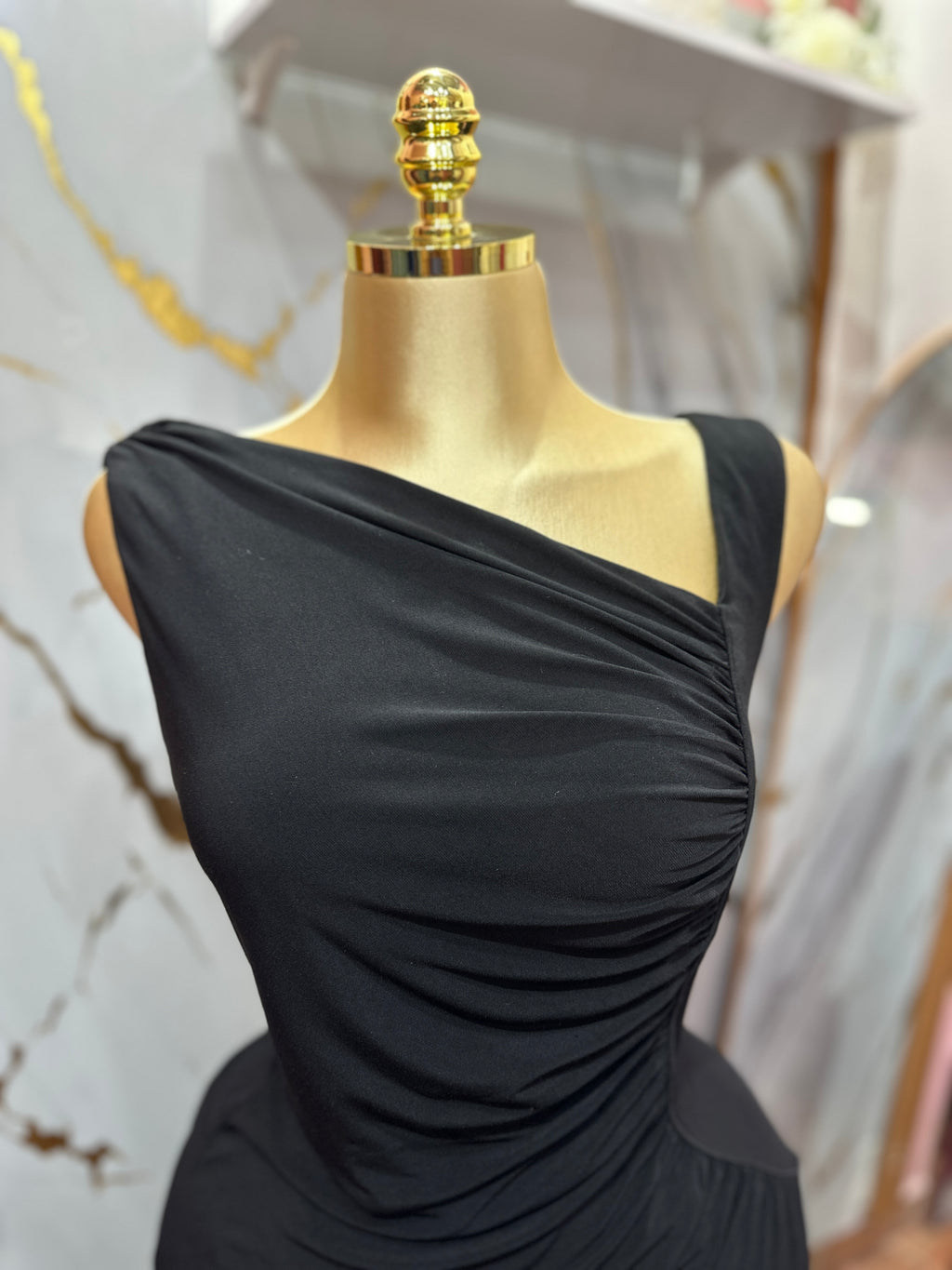 Vestido elegante negro con diseño asimétrico y detalles de drapeado