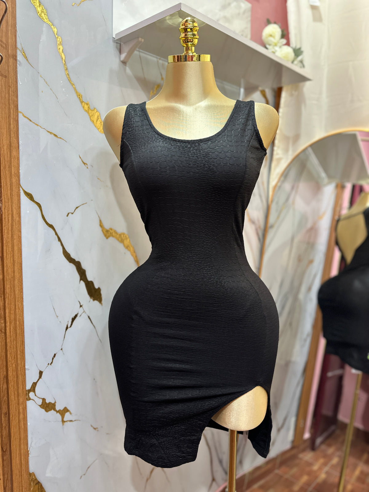 Vestido corto color negro ajustado con abertura lateral destaca por su espalda descubierta