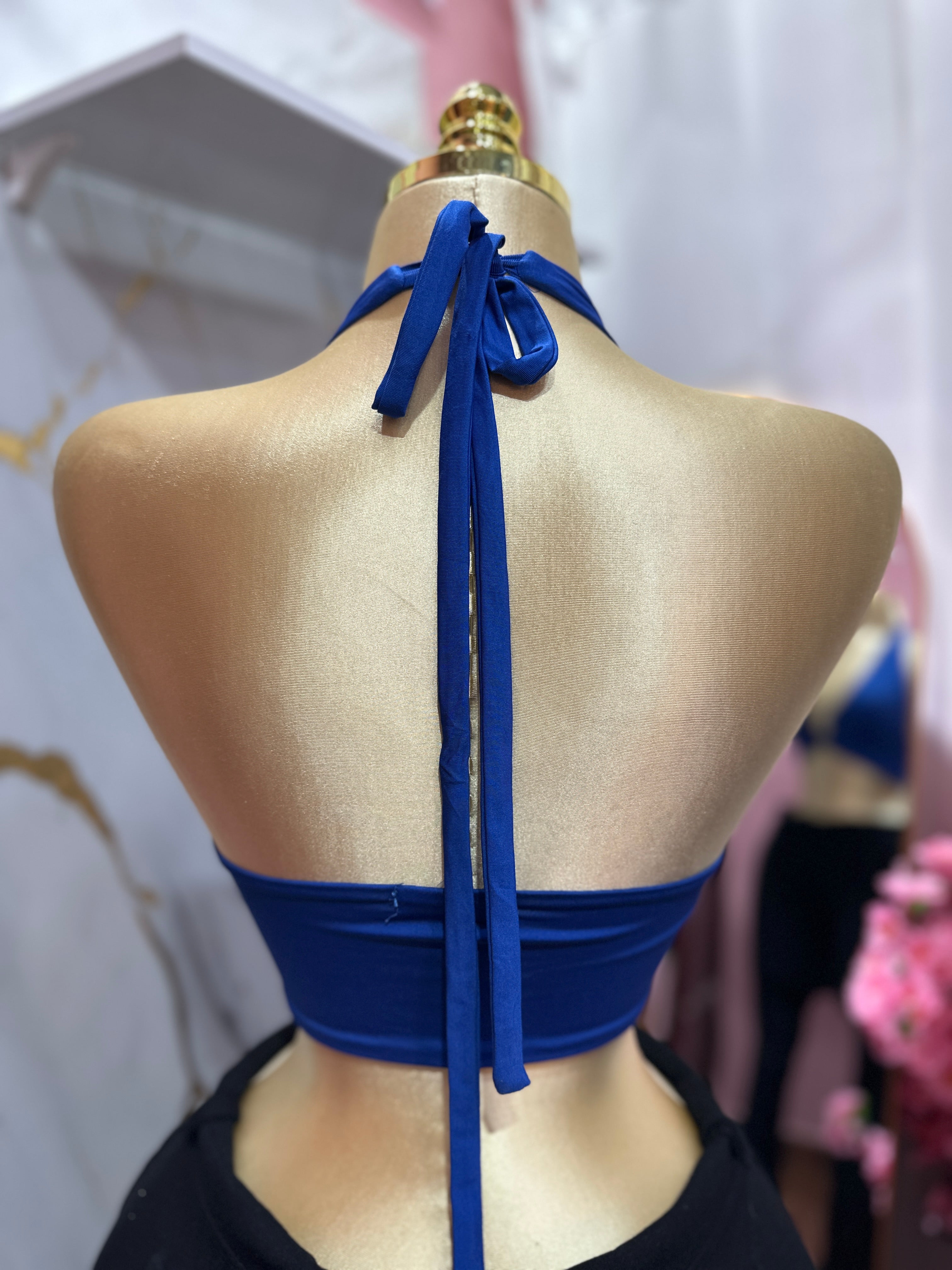 Top halter azul presenta un llamativo detalle de anillo metálico en el centro del busto