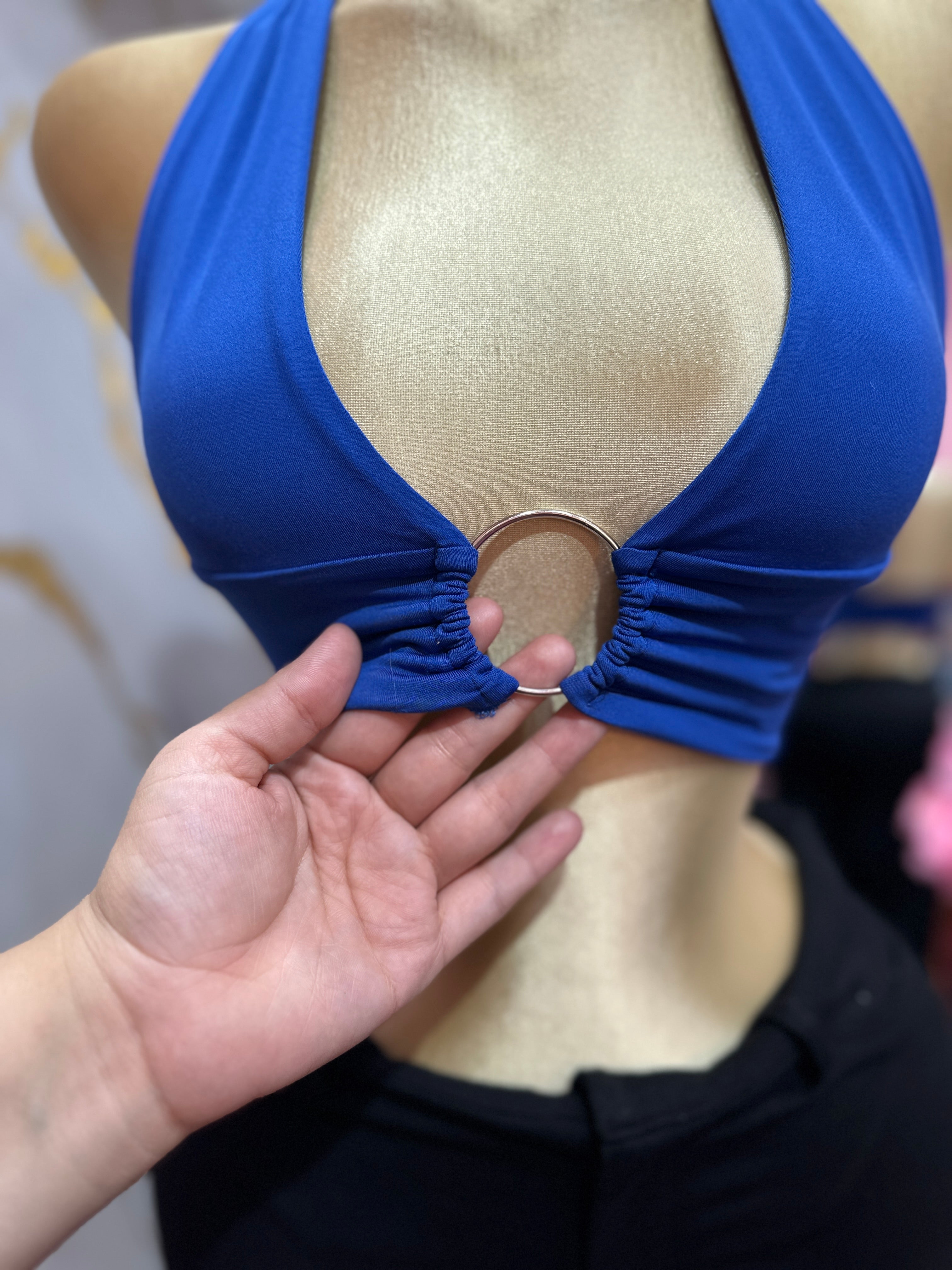 Top halter azul presenta un llamativo detalle de anillo metálico en el centro del busto