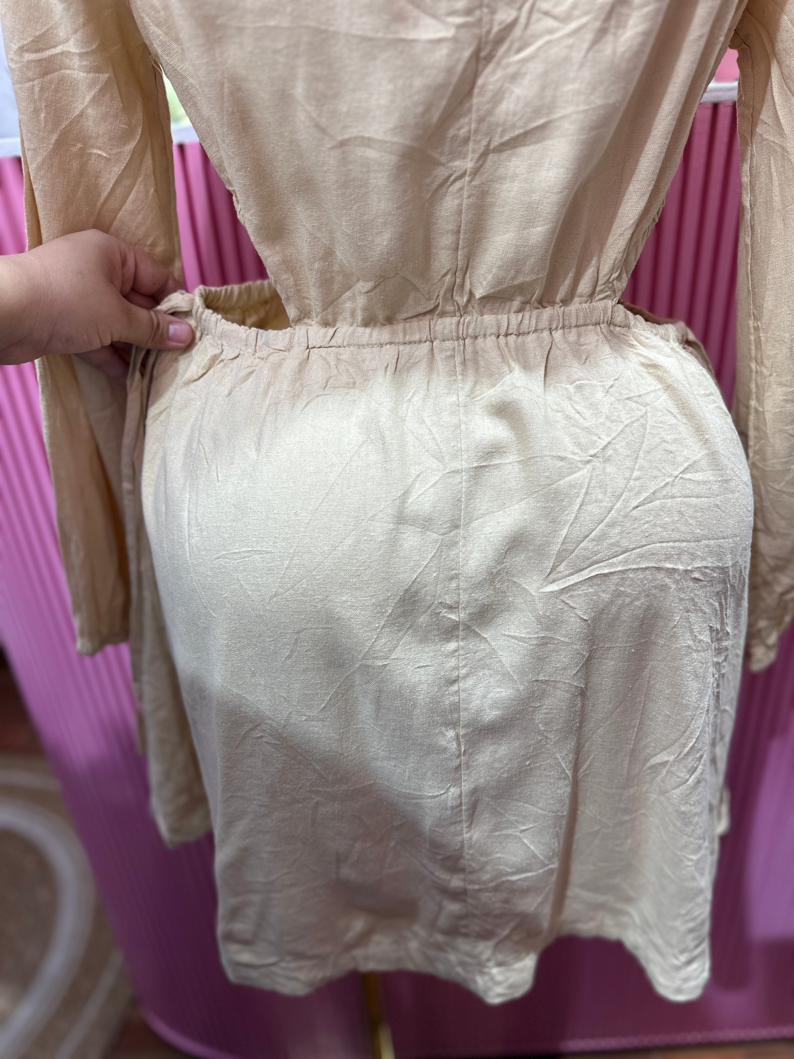 Vestido corto beige de manga larga con cintura elástica y abertura en los costados
