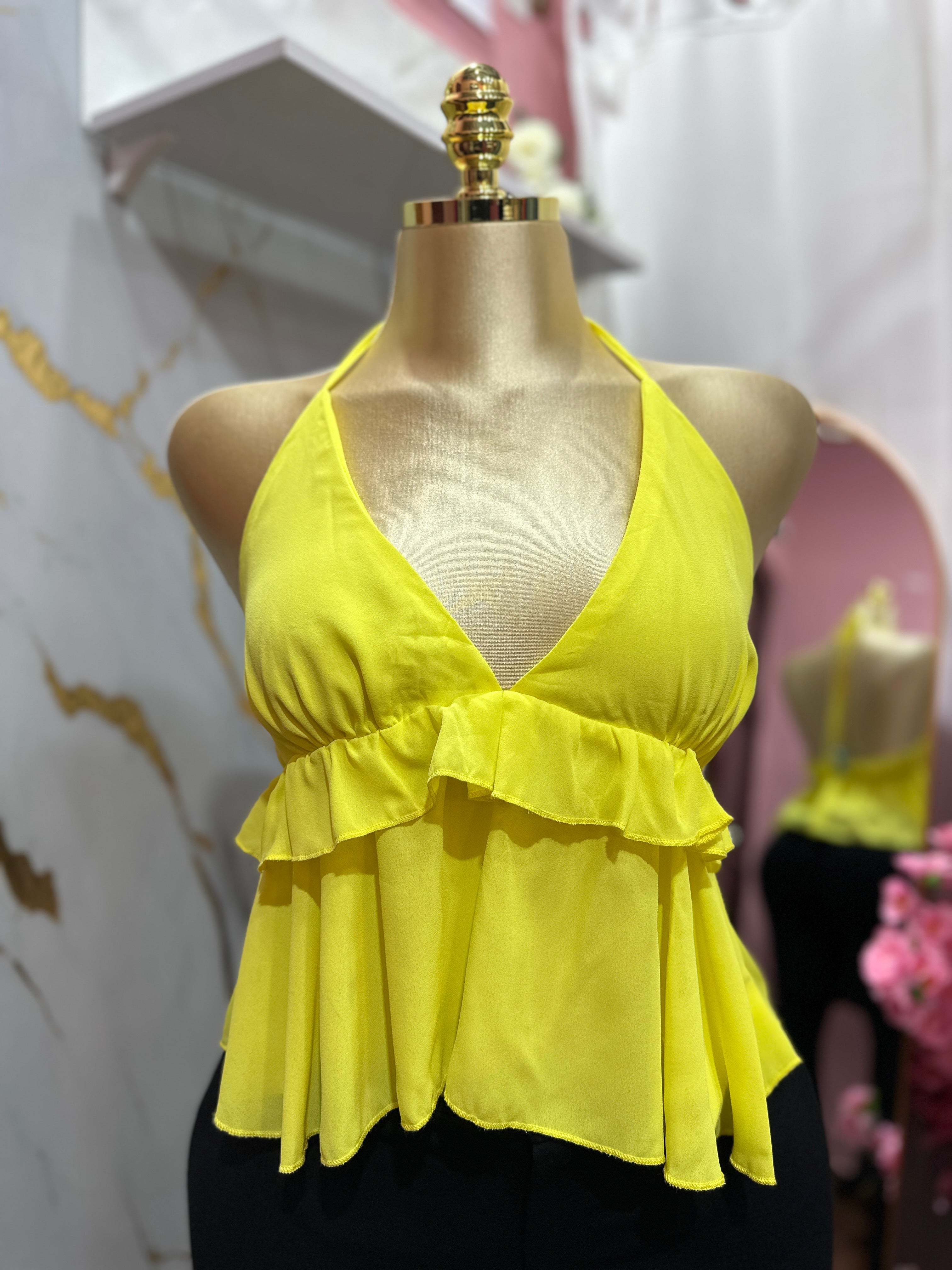Blusa amarilla con cuello halter y volantes en la cintura